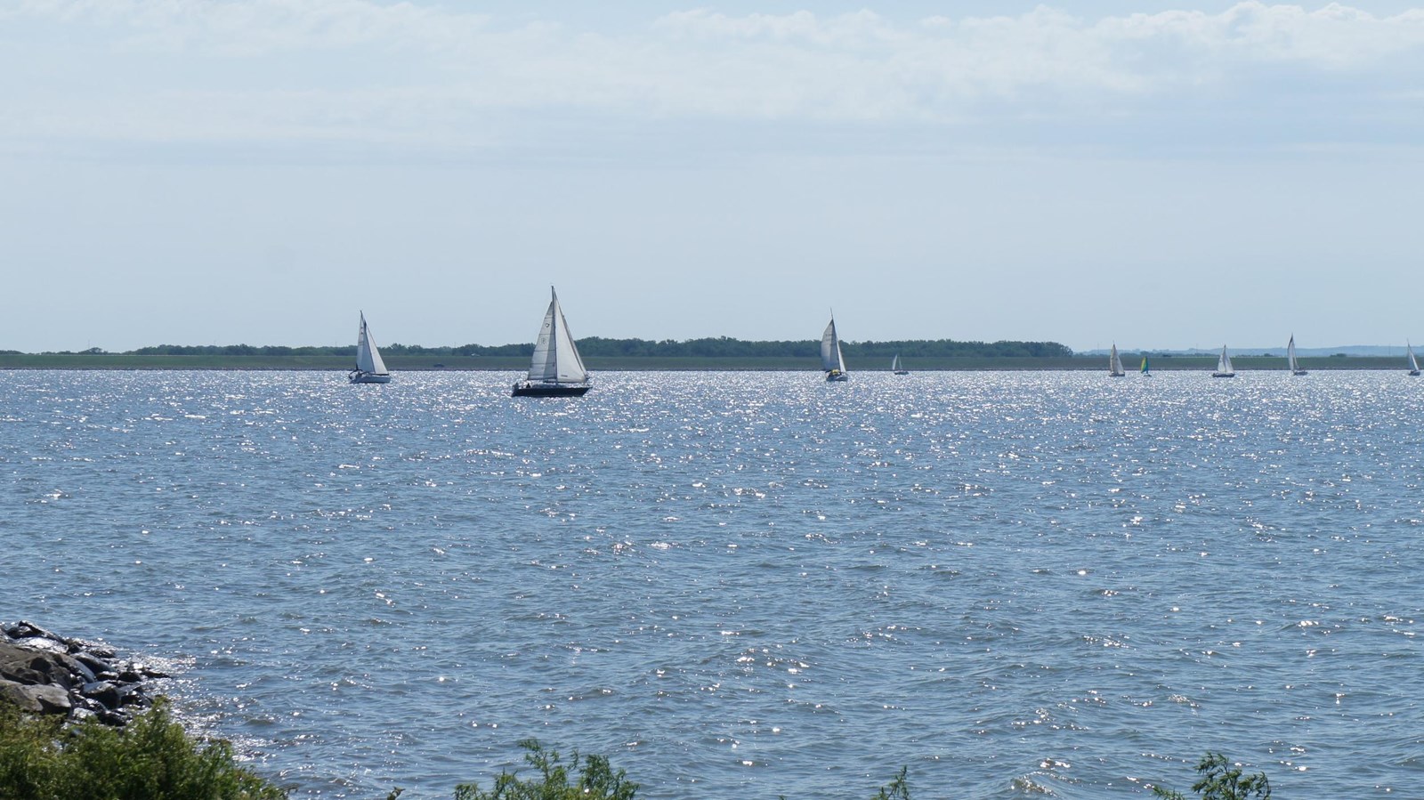 Sailboats on the water. Roads along the shoreline to prevent erosion. 