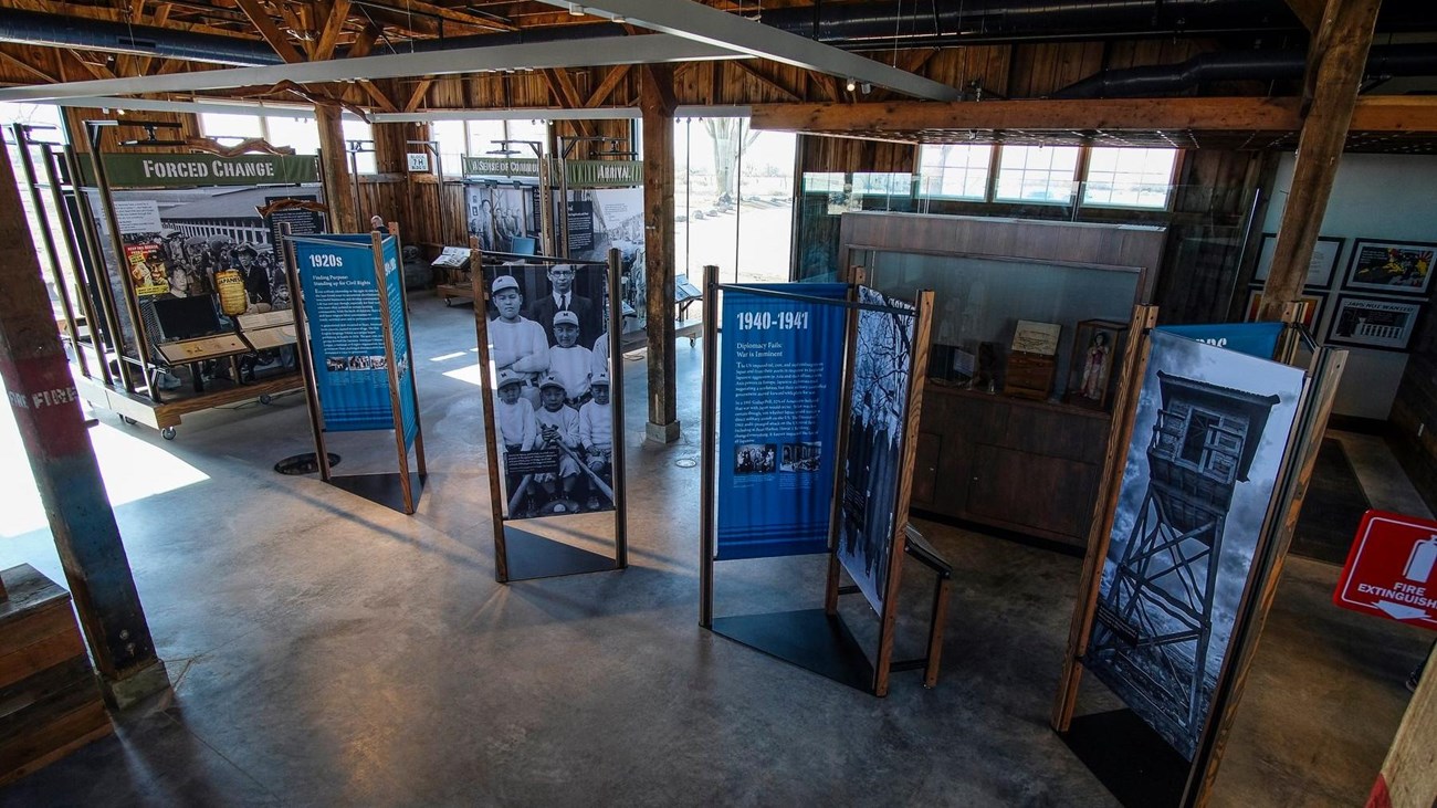 The rustic interior of the visitor center with upright panel displays on park history.