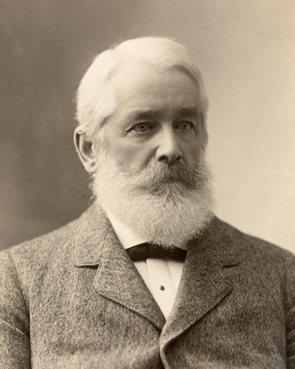 old man with white hair and beard wearing a formal suit