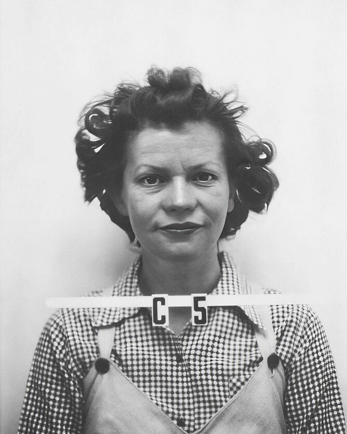 Black and white ID photo of a woman wearing a checkered shirt with &ldquo;C5&rdquo; written below her neck.