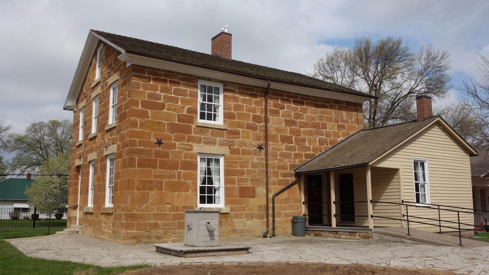 Red limestone 2½‑story jail with kitchen addition, yard, and window linked to Joseph Smith’s death.