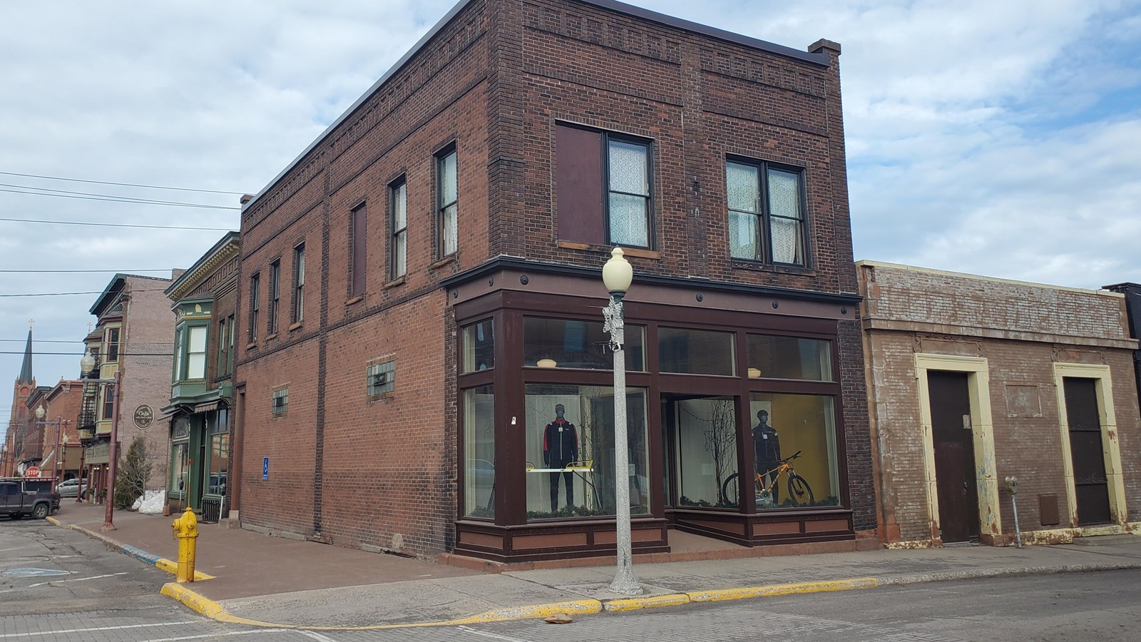 Two story brick building with large windows and roof corner caps.