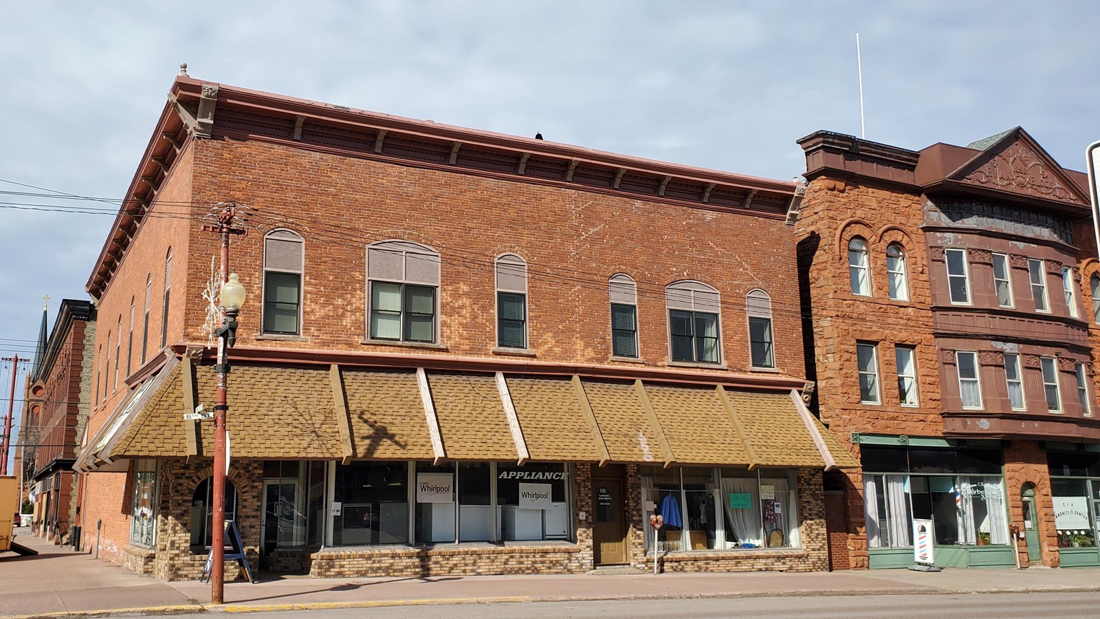 Two story brick building with a flat roof and yellow awning on the first floor.