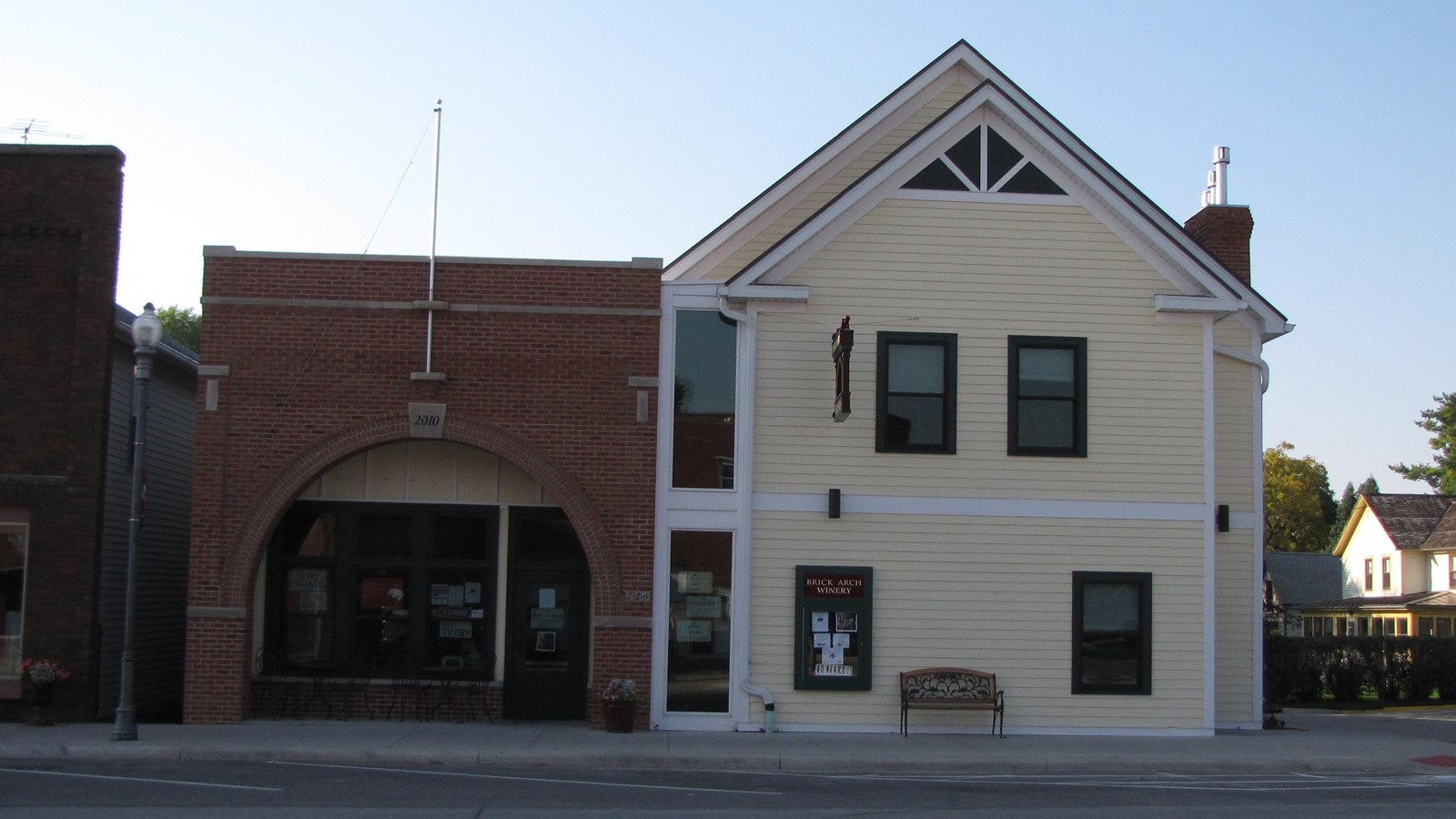 A downtown building appears to be two; one with a brick arch façade and one with a gabled roof.