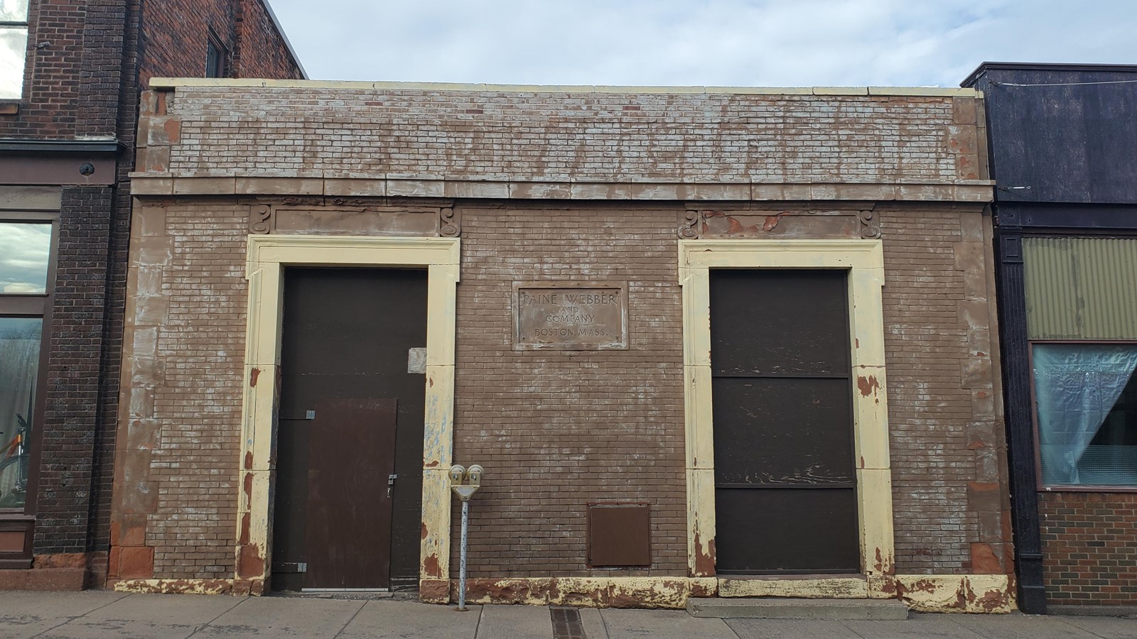 Blue/brown brick building with prominent metal doors.