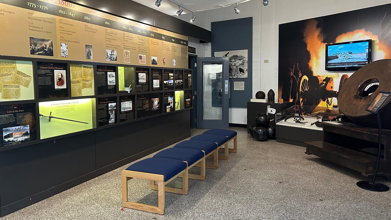 Museum with information panels on the left and cannon artifacts on the left.