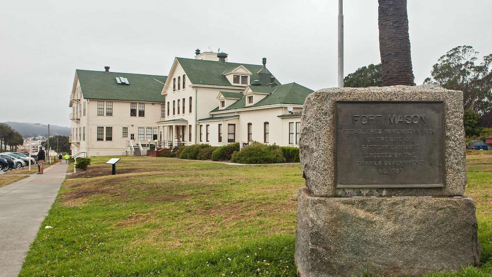 A plaque marking the establishment of Fort Mason and the Park Headquarters building in the backgroun