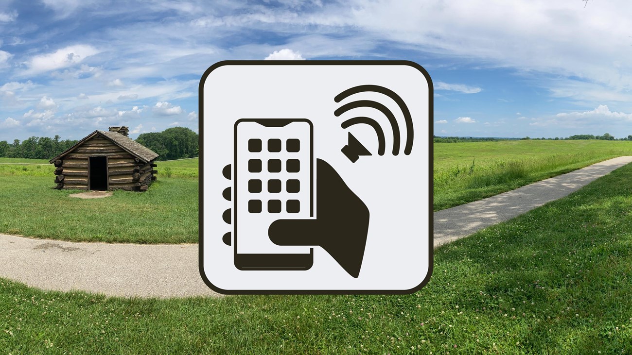 graphic of a smartphone and speaker with audio. the background shows a log hut and a paved trail.