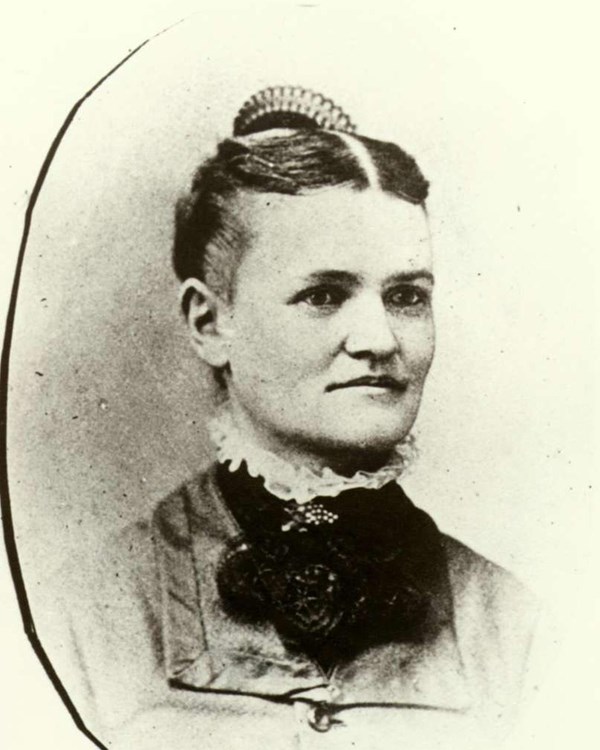 A 1879 portrait photo depicts a woman in a dress with parted hair and a comb.