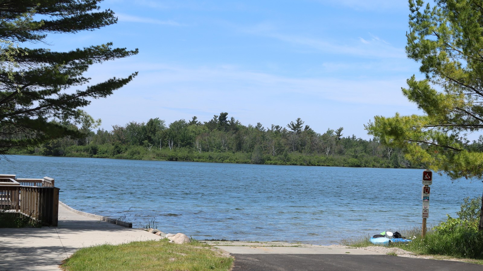 Looking across a boat launch and entrance to a fishing ramp, dark blue water ripples with the wind.