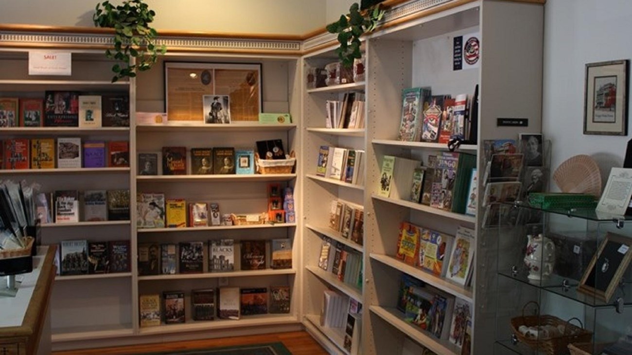 Shelving lined with books, souvenirs, postcards, soaps, and more gifts