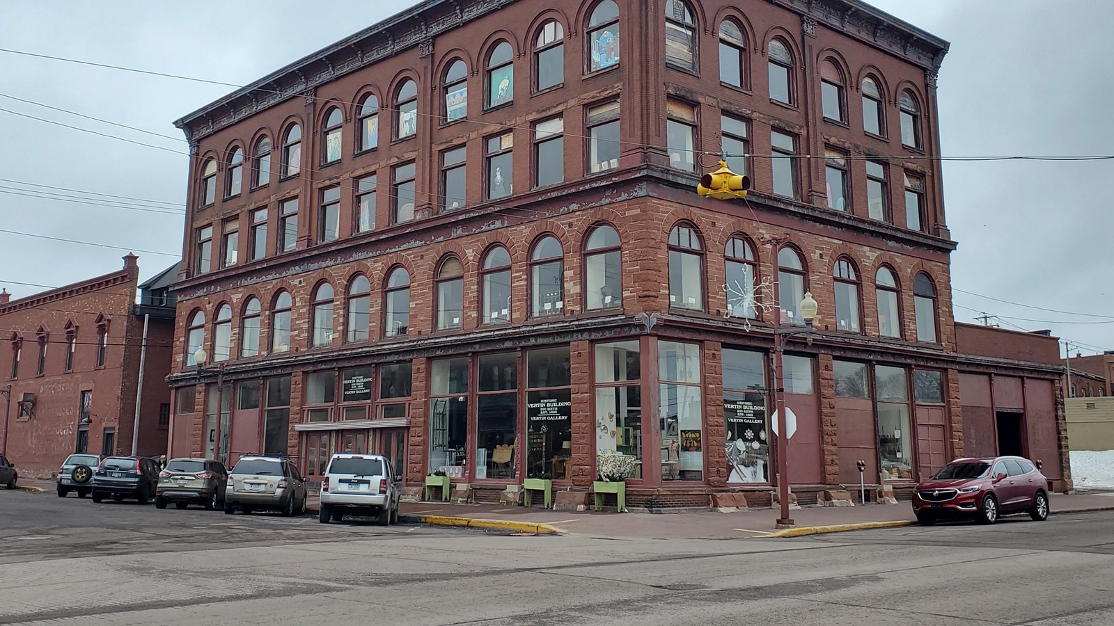 Four story brick and red sandstone building with large windows and ornate cornice.