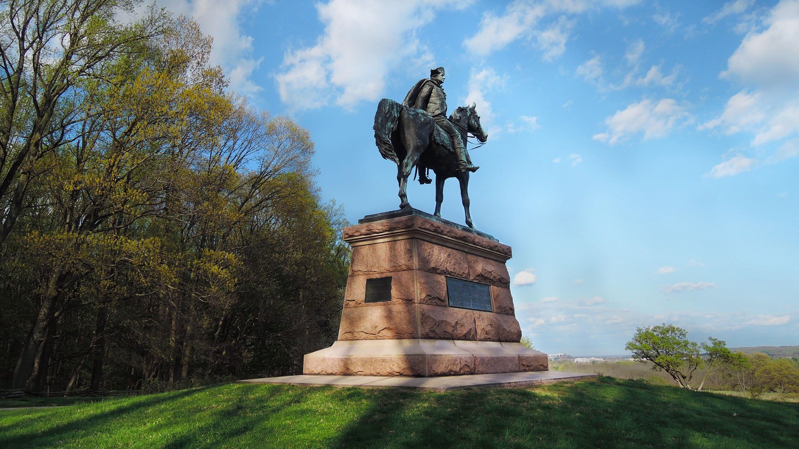 outdoors, grass, clouds, trees, monument, statue, horse, plaque