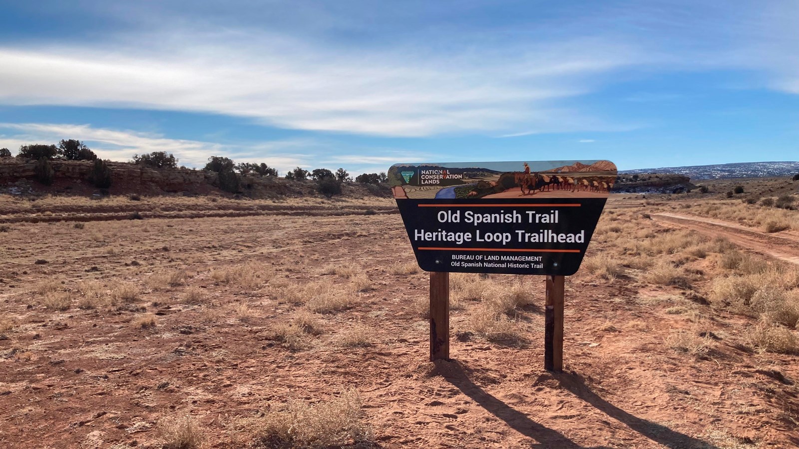 A open barren area with a trailhead sign. 