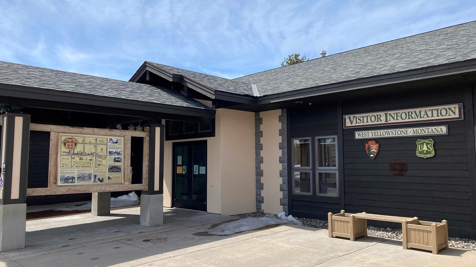 Entrance to visitor information center with signage a bench in front