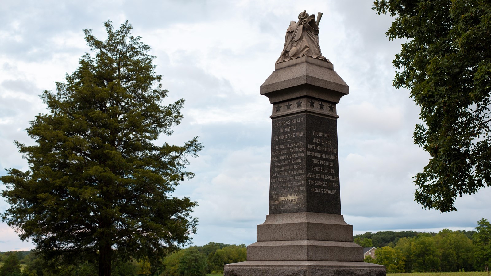 A marble monument overlooking a farm