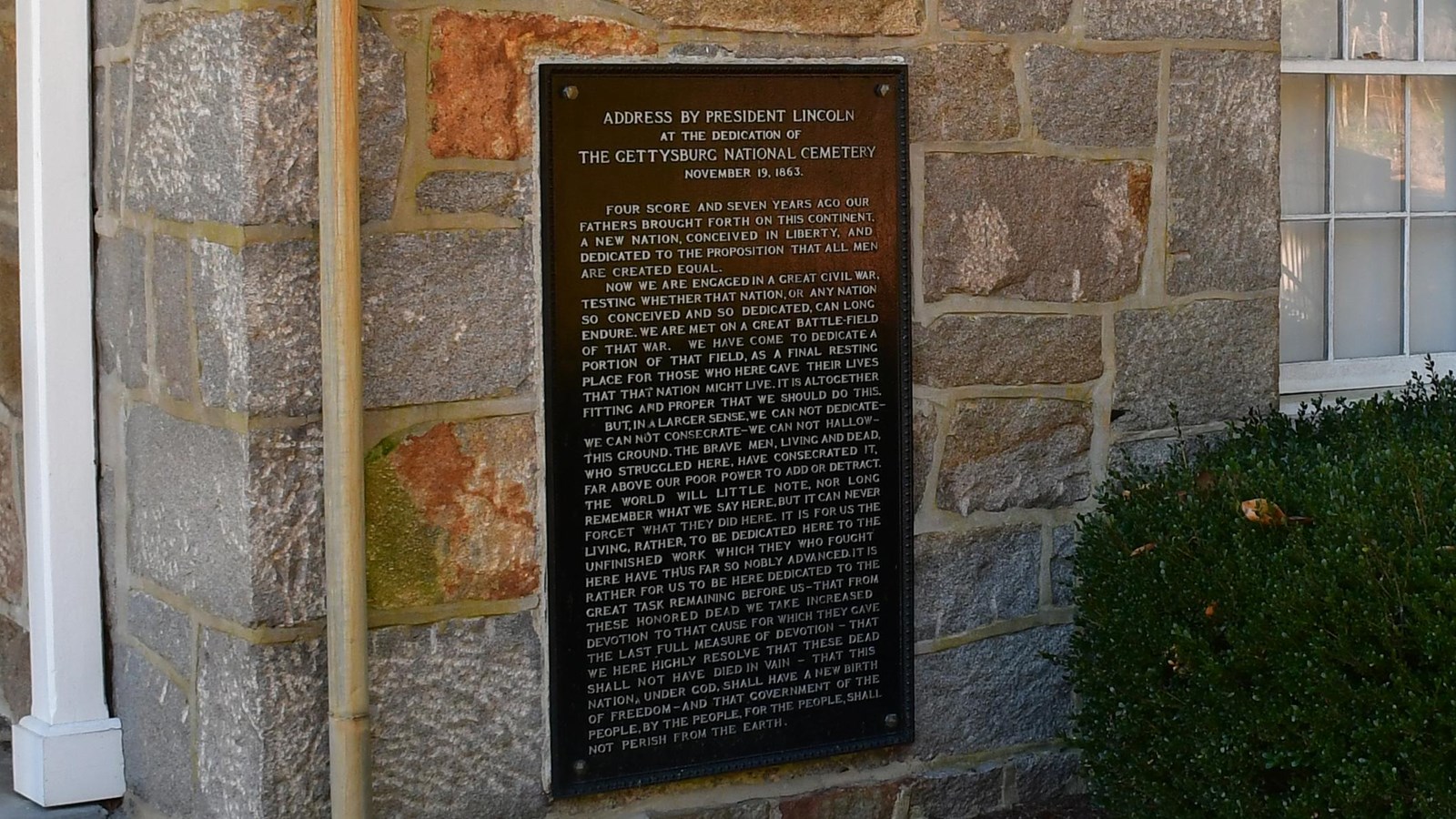 Black plaque with the text of the Gettysburg Address in raised silver letters.