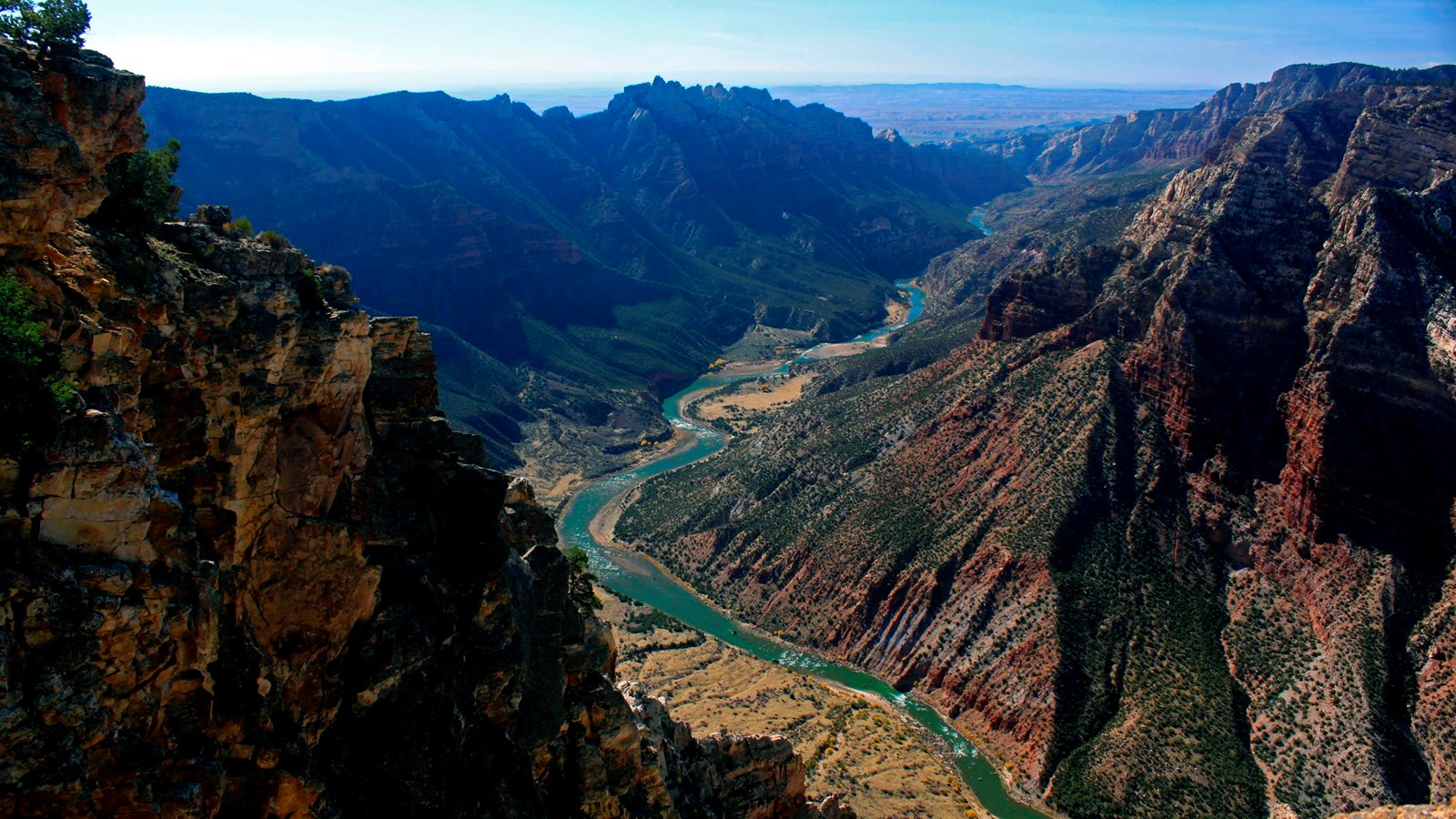A view peering down into a canyon where a river carves through.