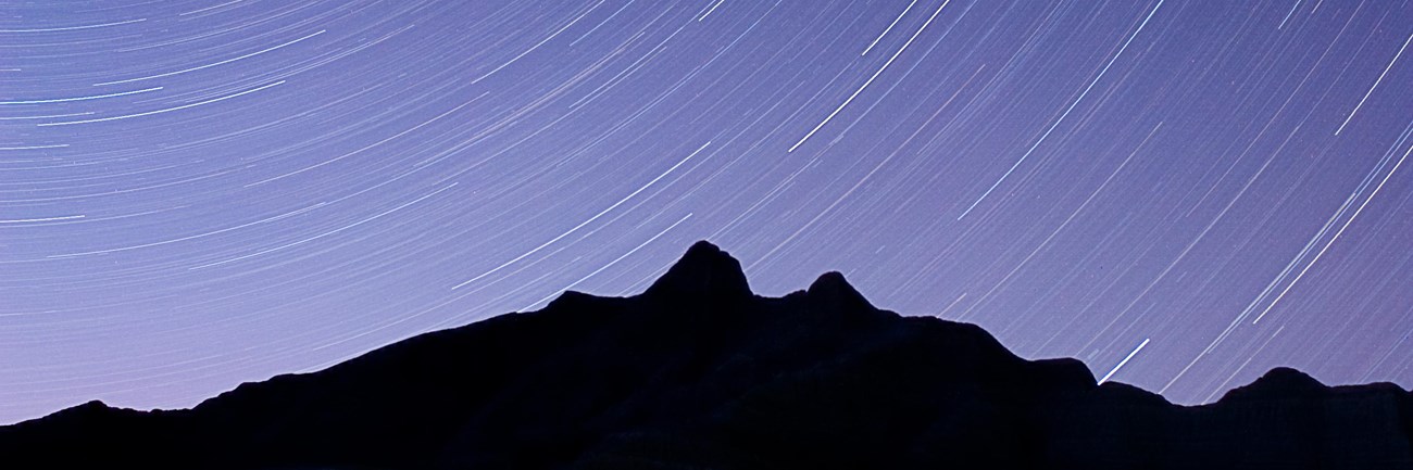 stars whir around the silhouette of a badlands butte in a circular motion