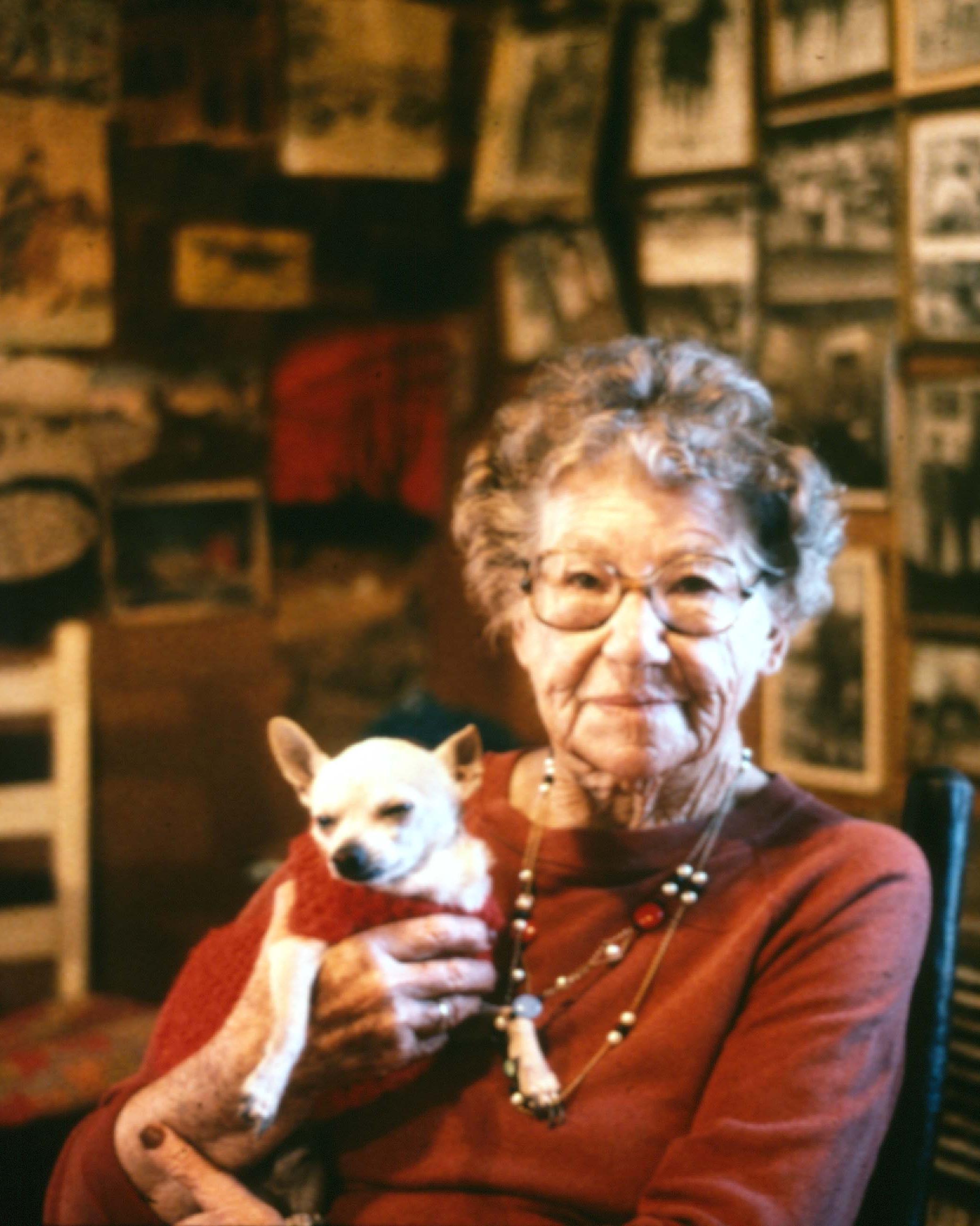 An elderly woman holding a dog