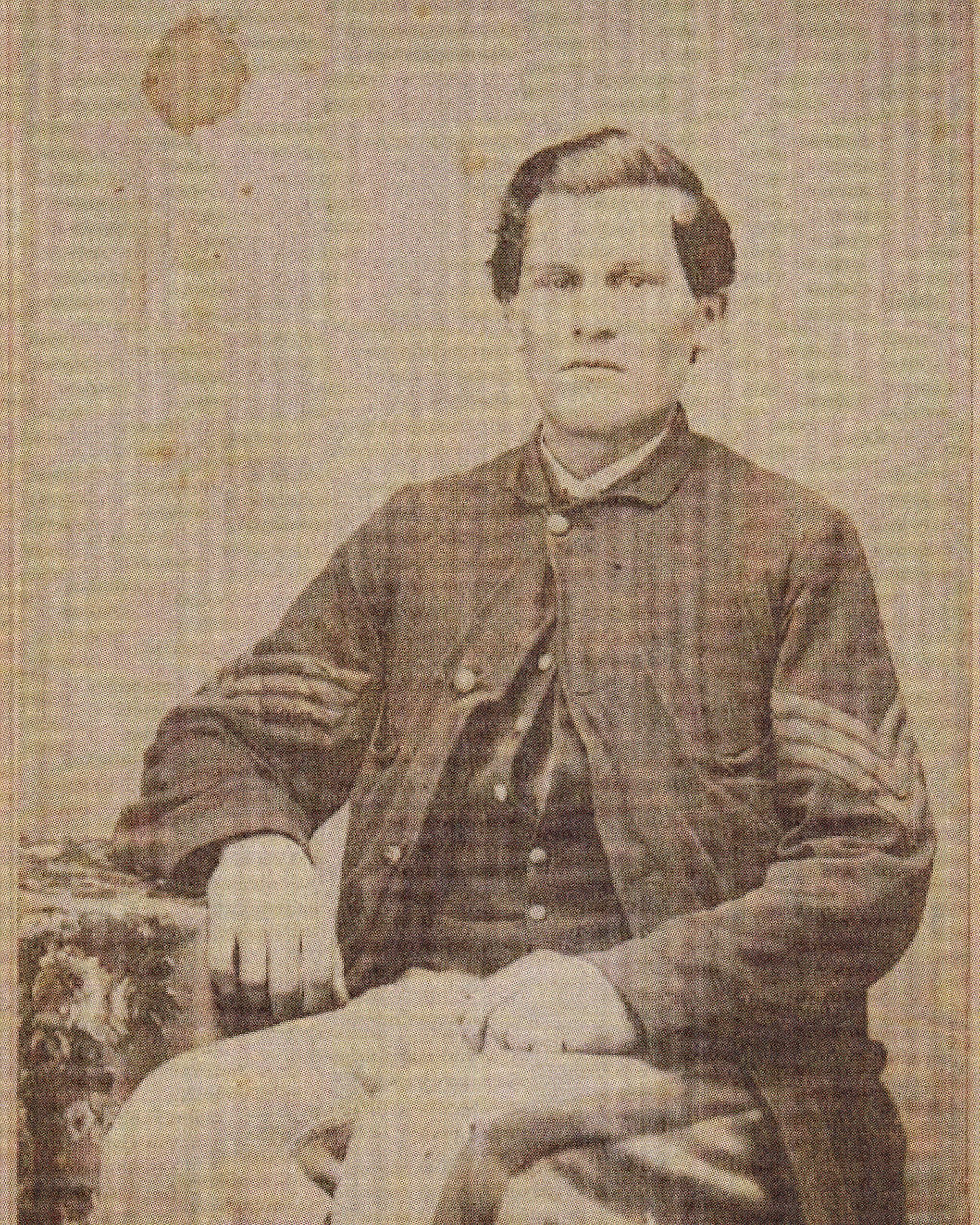 Portrait of a young man, seated, in an officer's military uniform. 