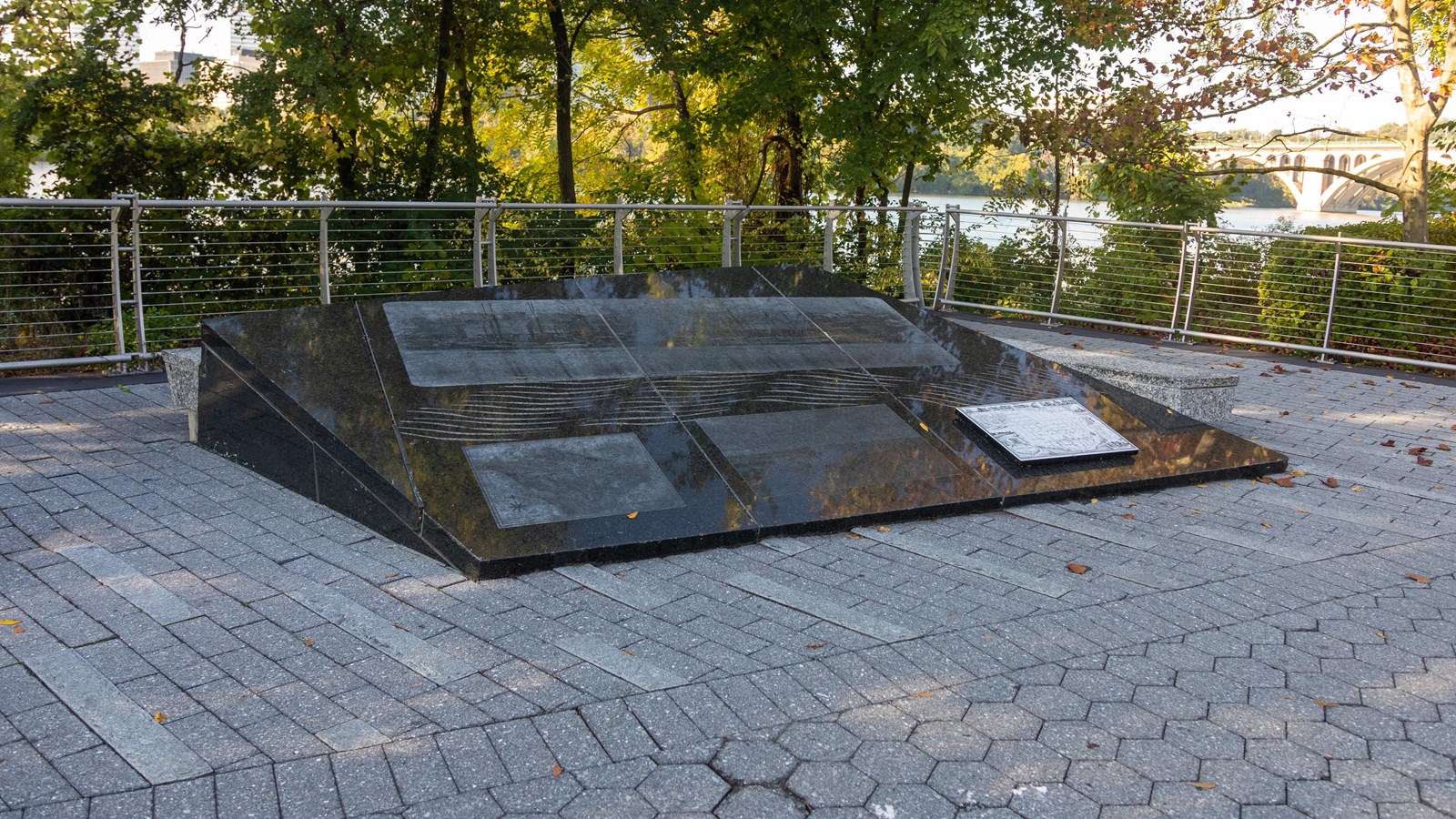 A triangular stone sculpture with etchings.