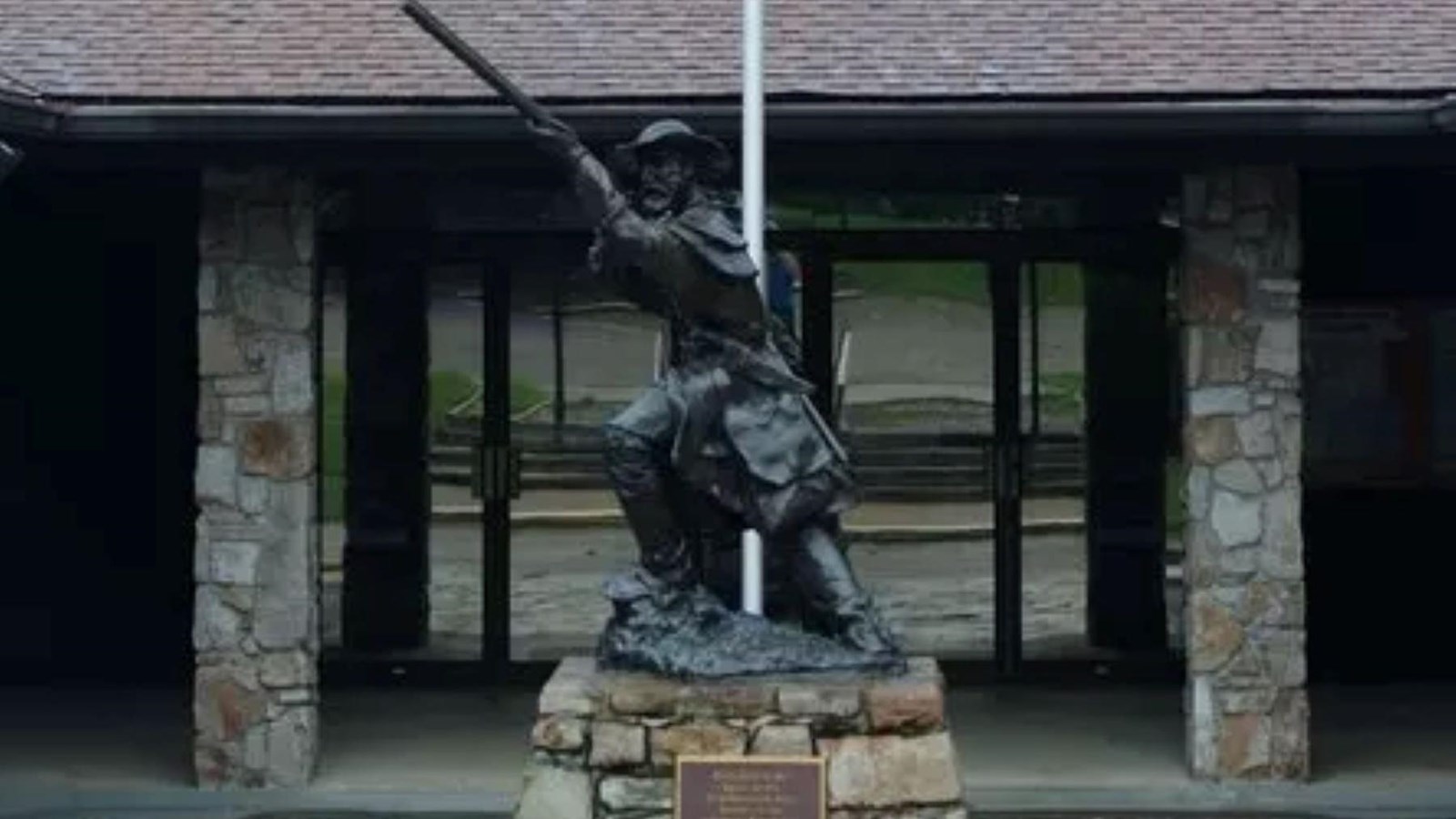 A brick building with a statue of a soldier in front of it.