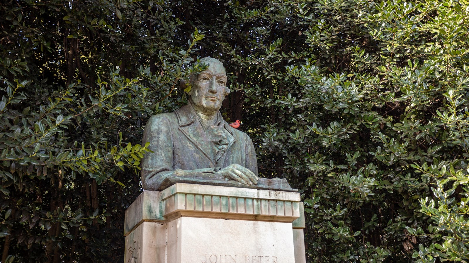 A statue of a man on top of a stone monument. 