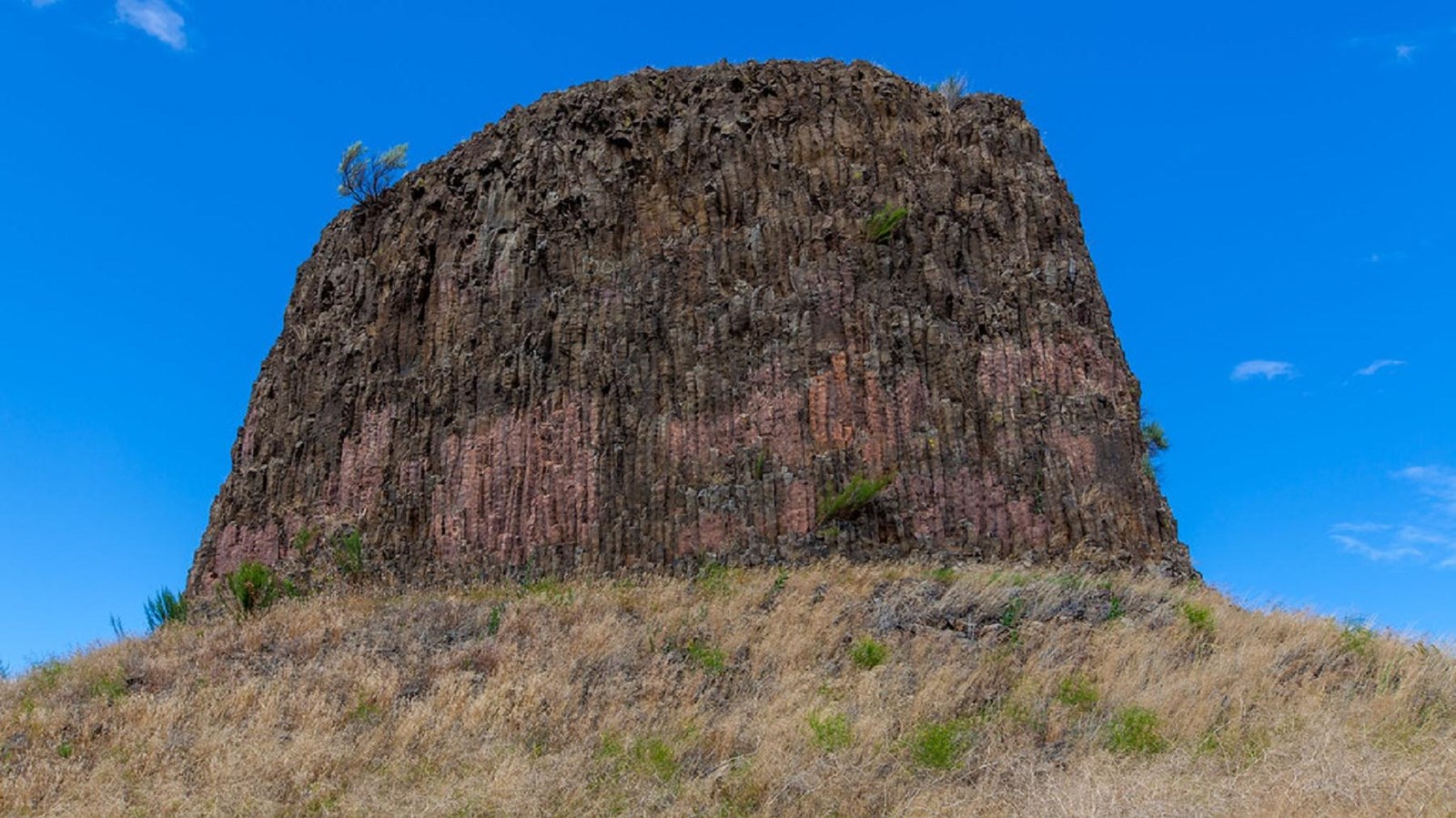 A hat shaped bluff rises from a grassy plain