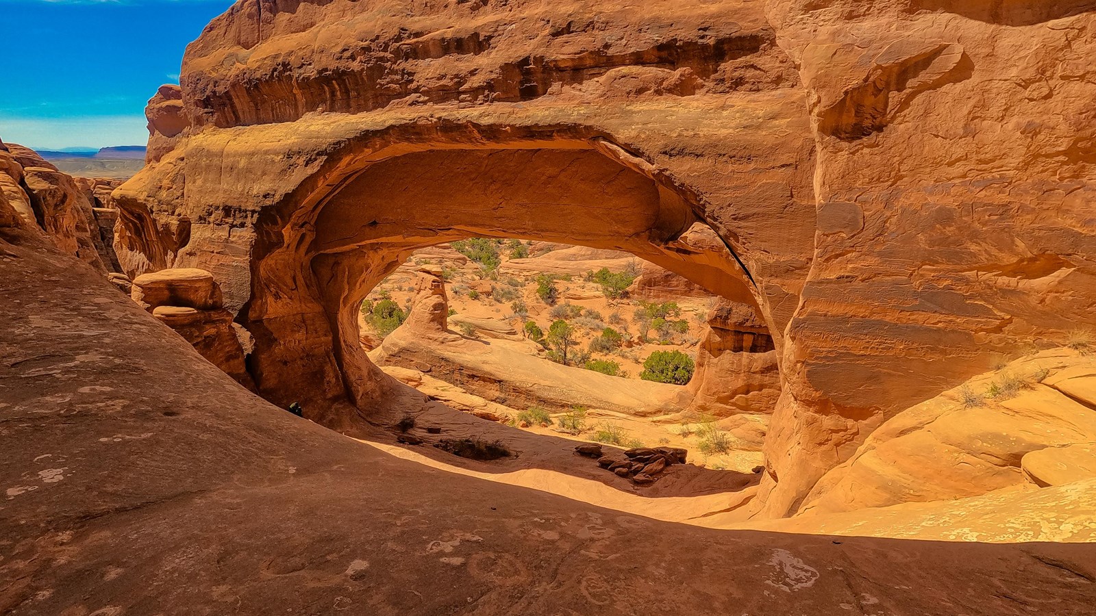 A stone arch opening frames a view of the valley below