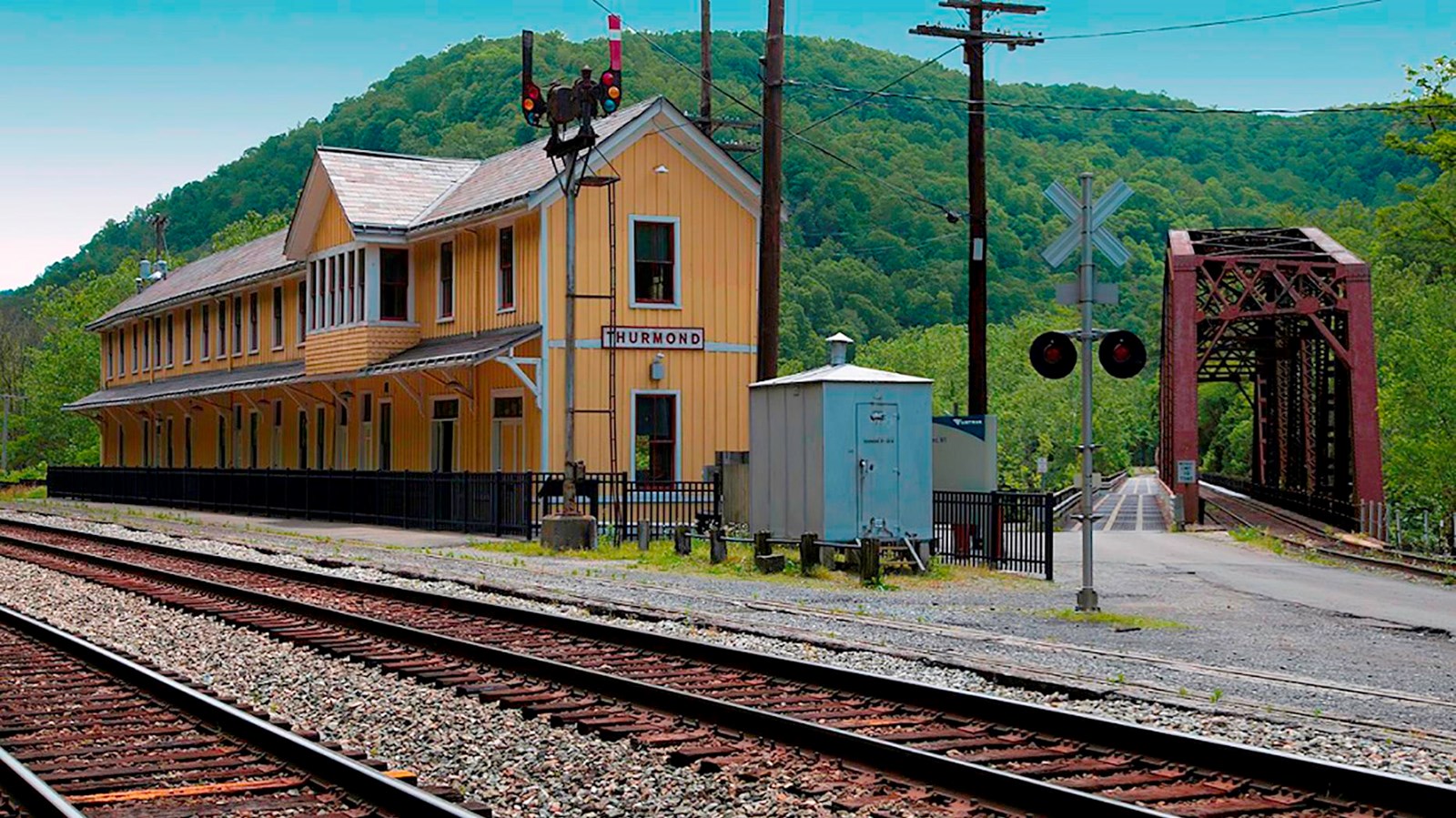 old yellow railroad depot alongside tracks