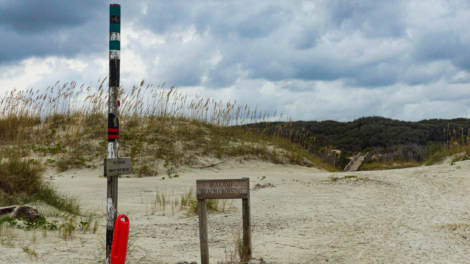 A black and white pole and sign with text 