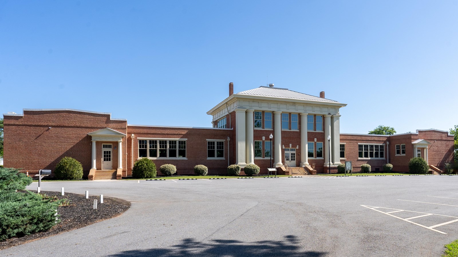 Plains High School is a red brick building with large columns at the top of stairs