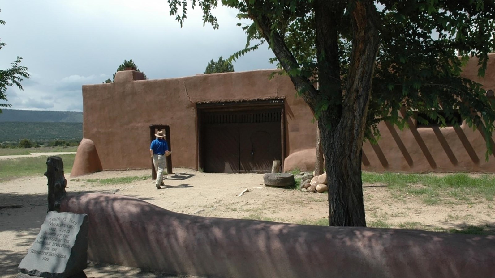 A man walks into a small adobe building