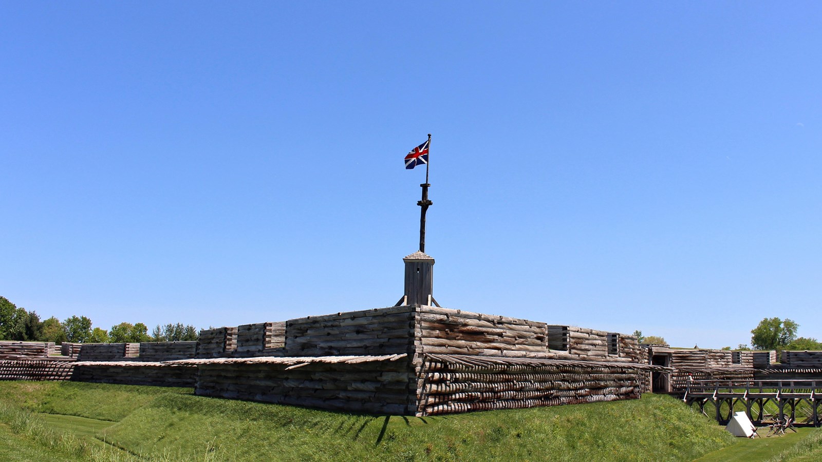 A red, white, and blue flag flies over the fort\'s wall.