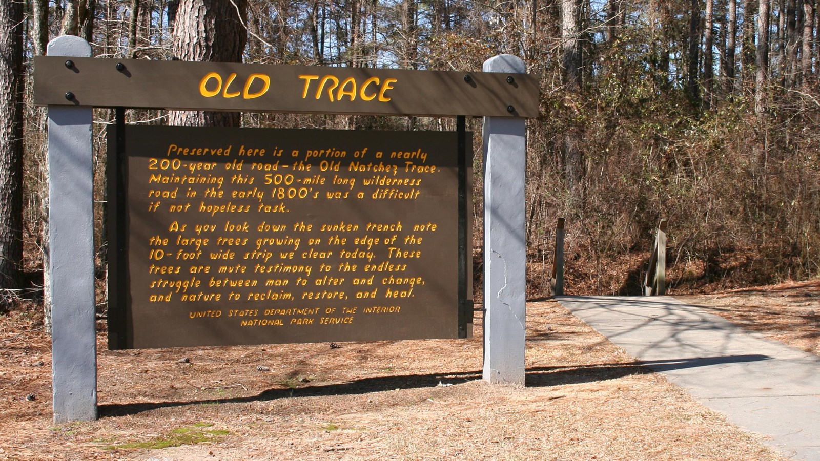 Brown painted sign with yellow letters tells about Old Trace at this particular location.