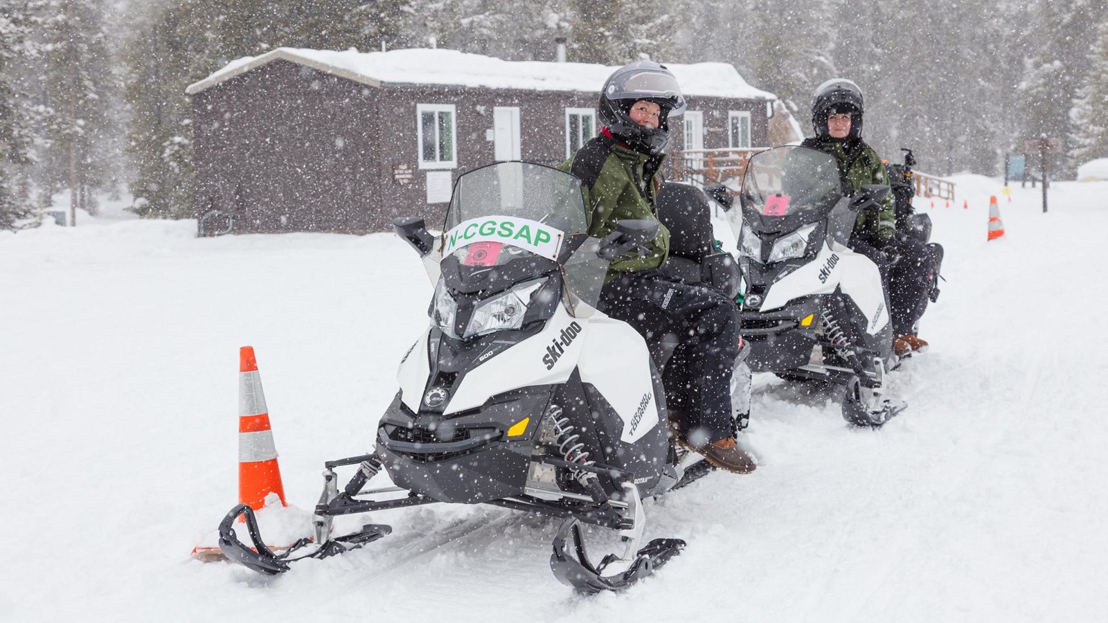 Non-commercially guided snowmobile group parked at warming hut