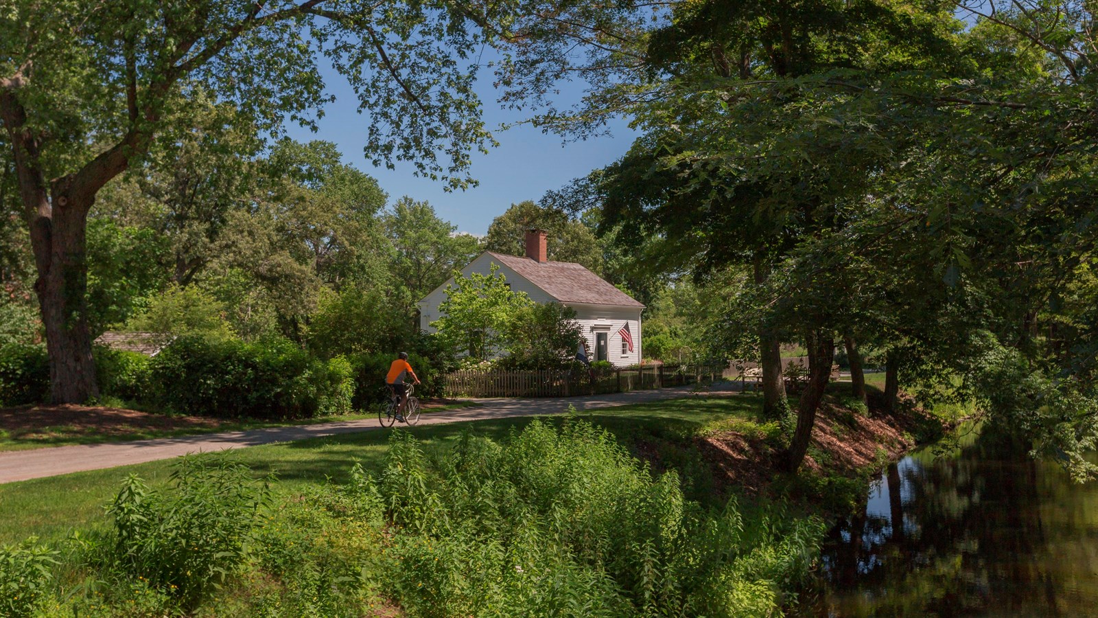 White building with chimney with path and canal in front