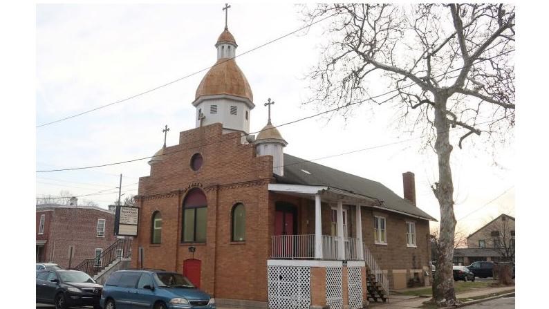 church building with brick ornamental facade attached to a rectangular brick building 