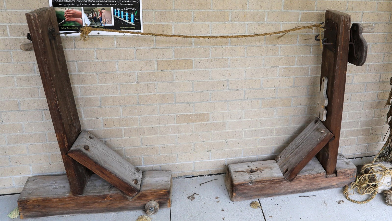 Wooden structures face each other with a rope in-between attached to a crank.