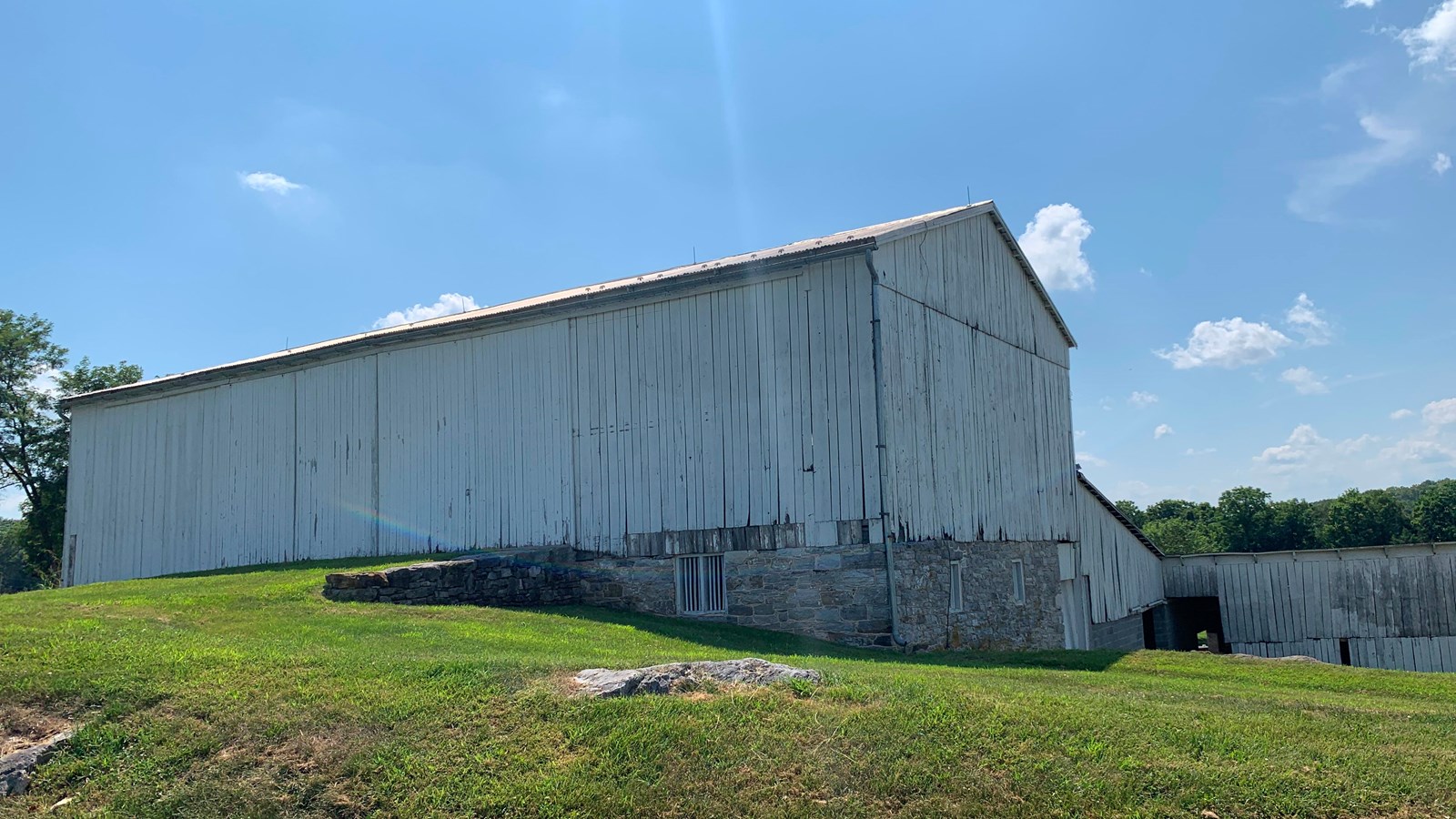 white barn with grass driveway 