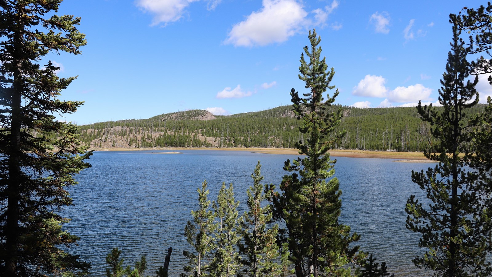 A lake surrounded by rolling hills and forests.