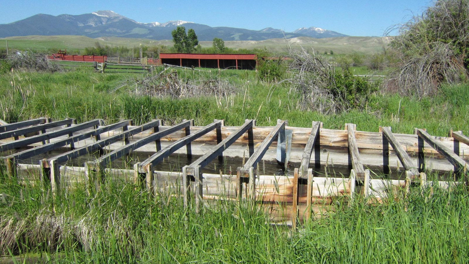A, long wooden flume transports water from a man-made ditch over the top of Johnson Creek.