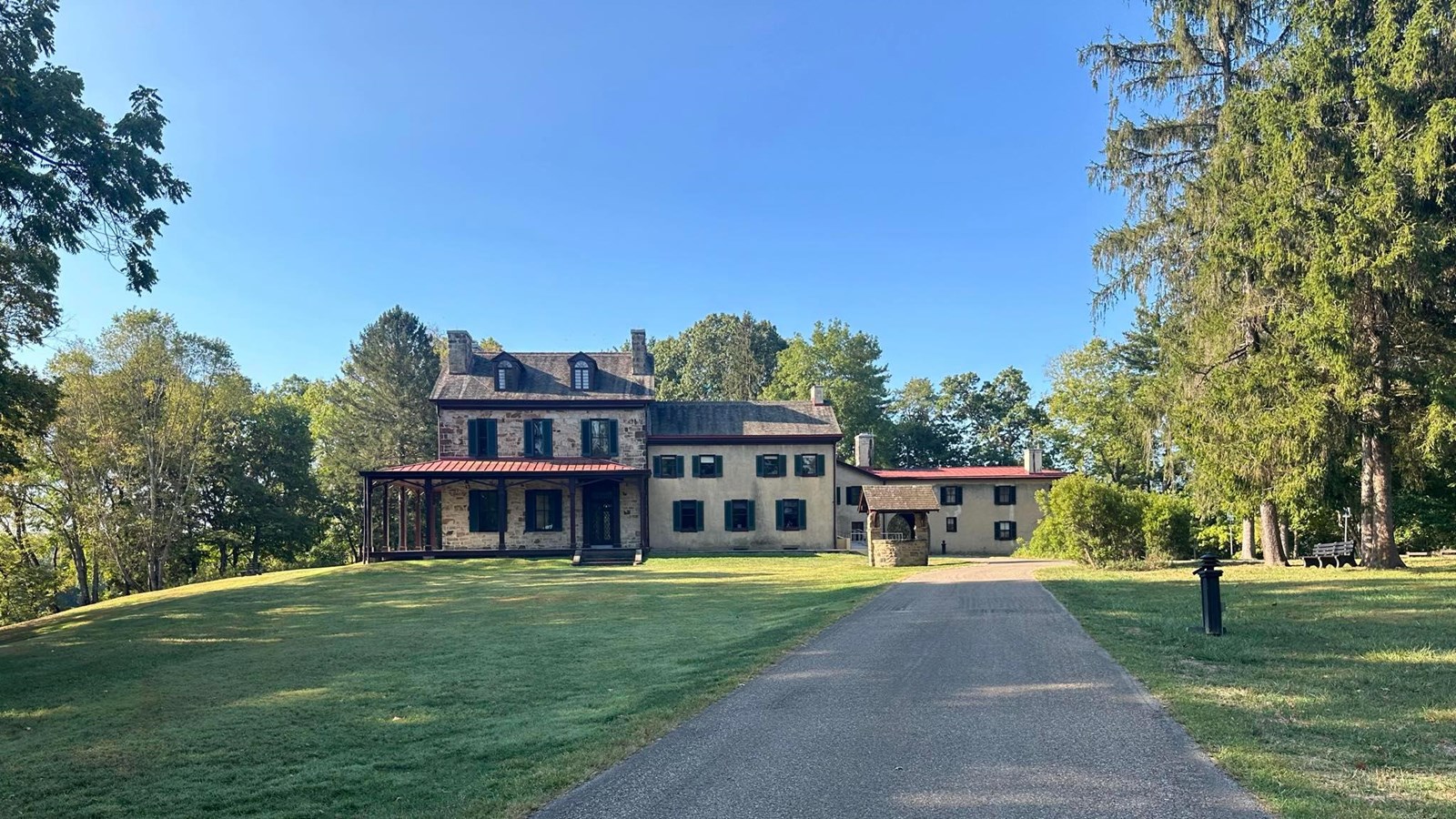 Large historic building with large lawn and macadam driveway