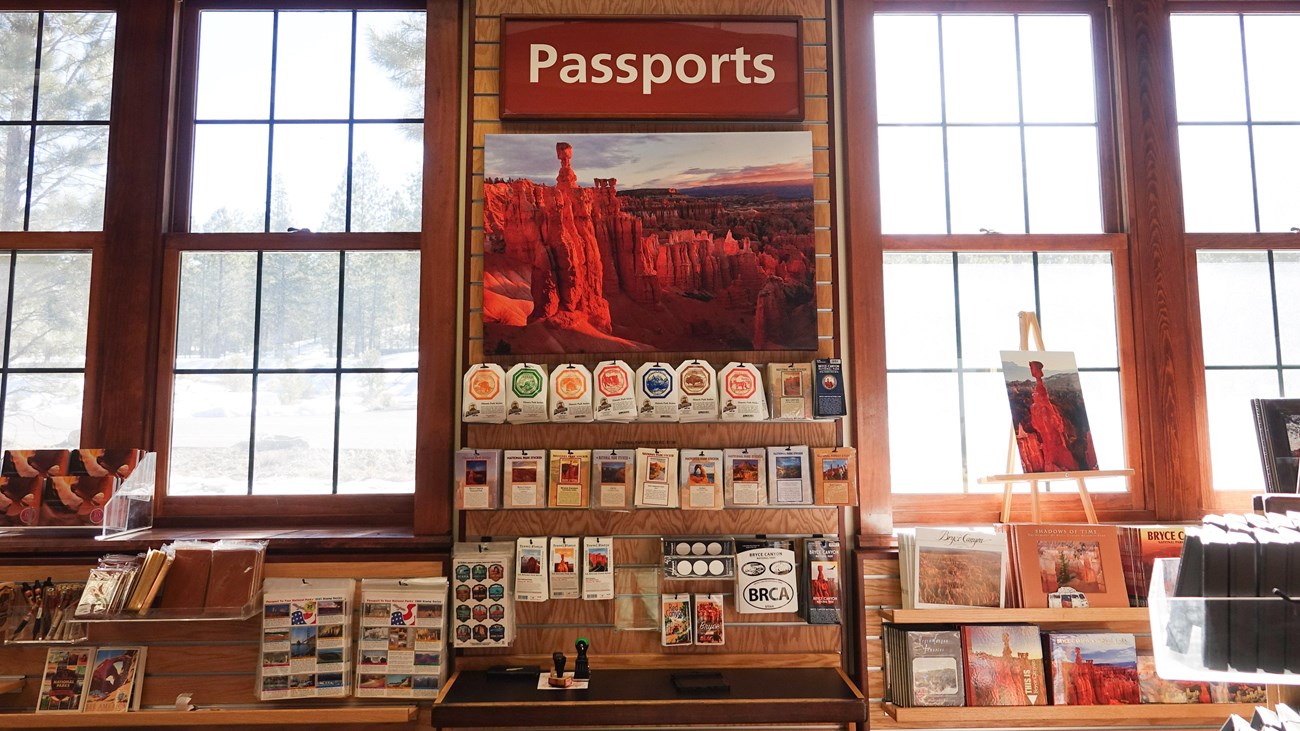 A merchandise display between two windows reads Passports with many stickers and stamps.