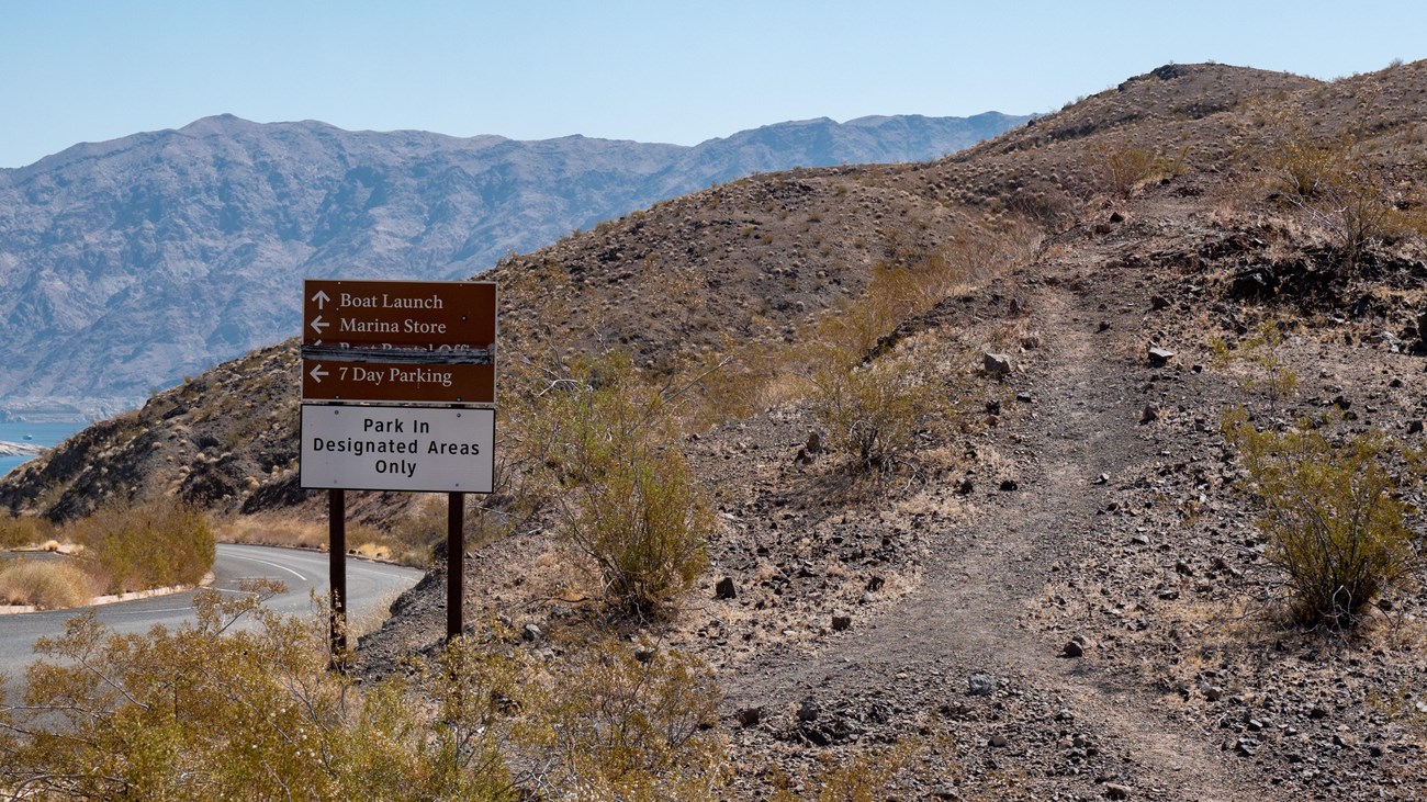 A trail next to a sign.
