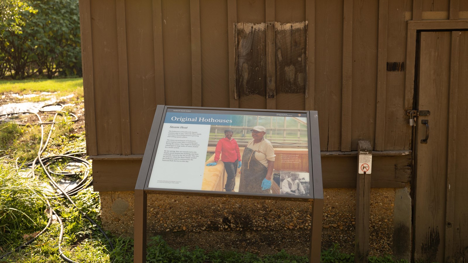 A information panel in front of a large brown building