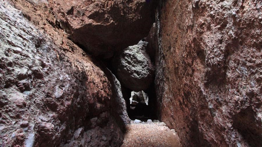 Large boulder wedged in narrow rock canyon.