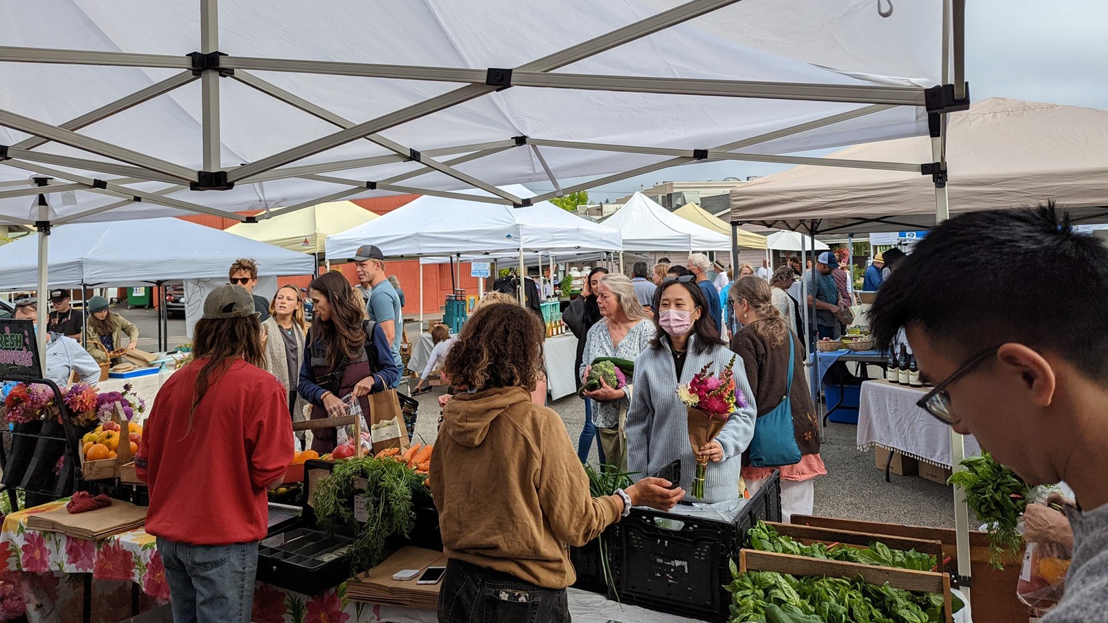 a large group of people under a canopy in a bustling outdoor market