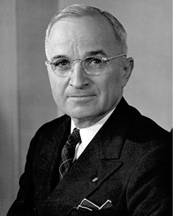 A balck and white photo of a man in glasses looking at the camera.